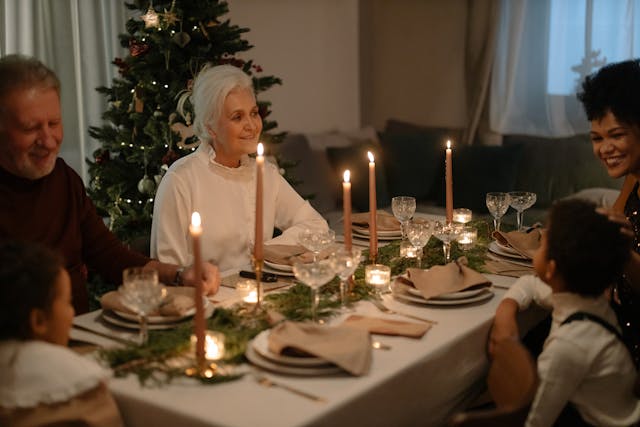 Repas de Noël en famille avec les grands-parents et un sapin en arrière-plan