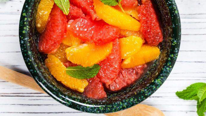 salade de fruits pamplemousses et oranges dans bol noir vu de haut