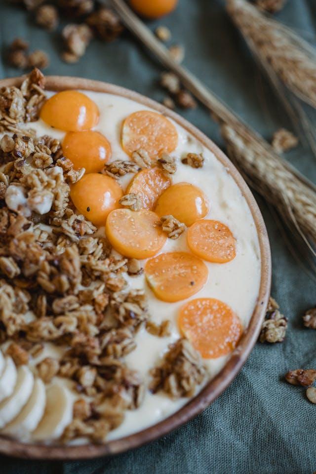 Assiettes en bois avec des céréales, rondelles de bananes et de tomates cerises et des épis de blé à côté