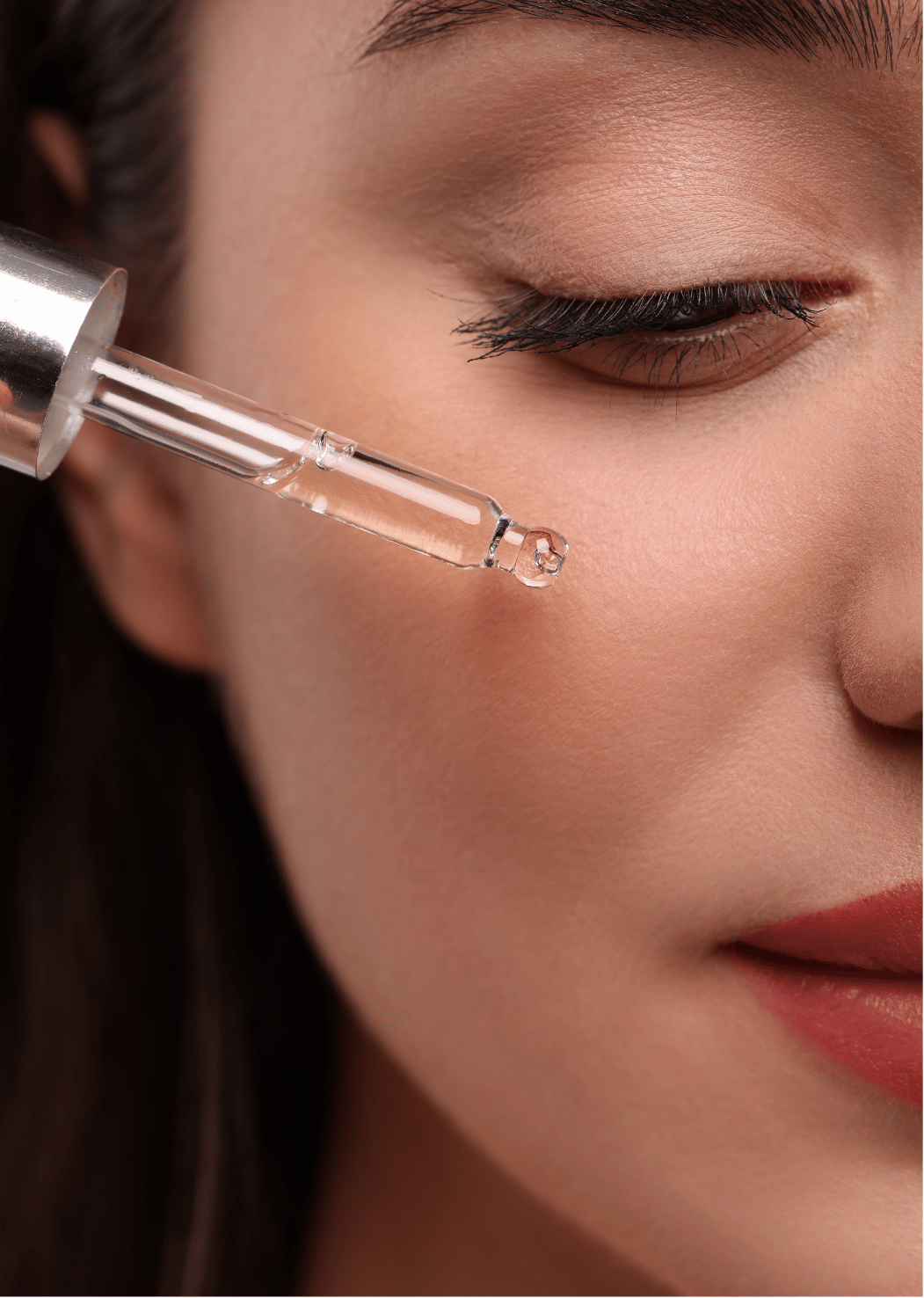 Visage femme avec pipette huile sur sa joue