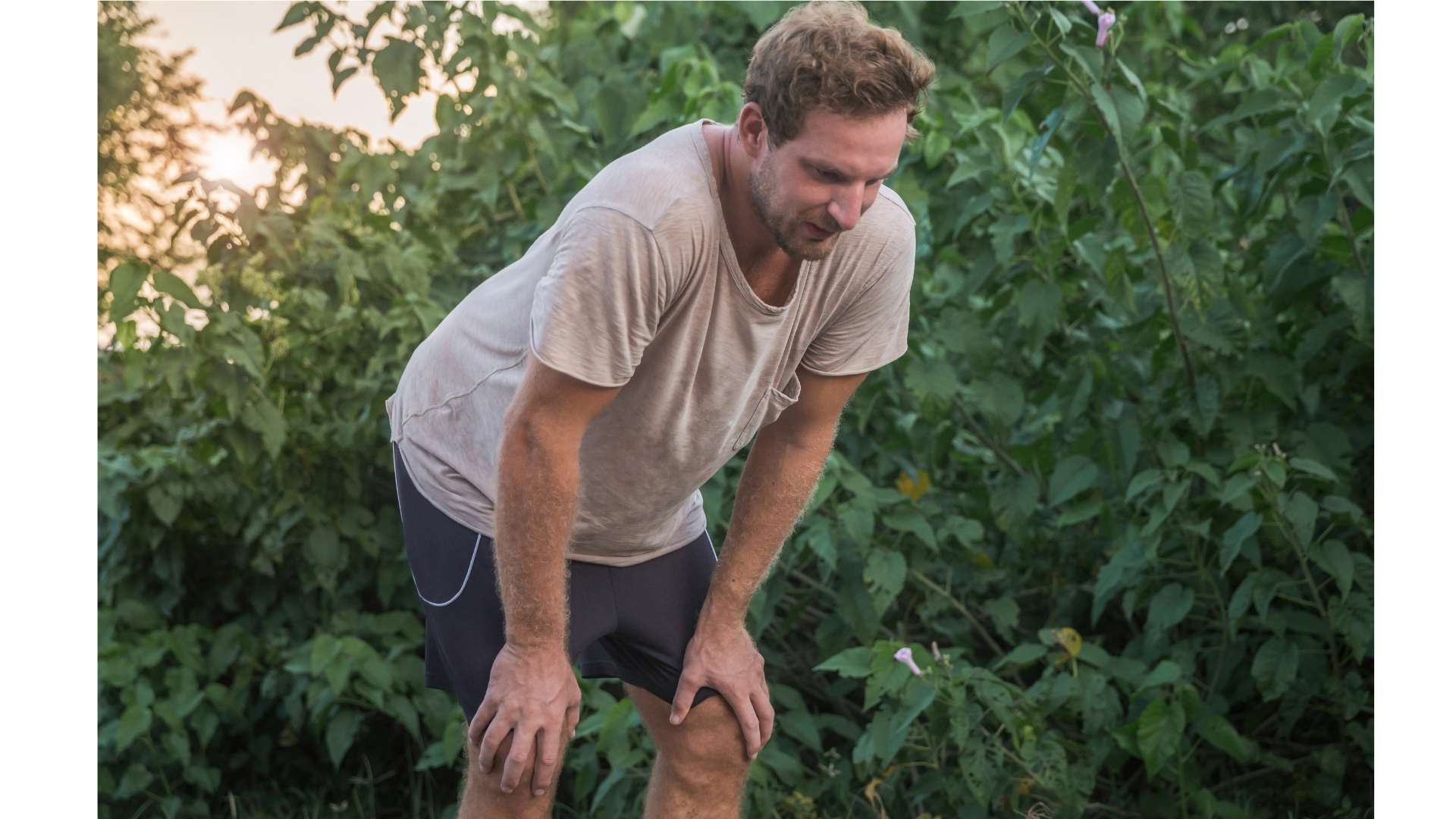 Homme en tee-shirt et short les mains sur les genoux qui reprend son souffle