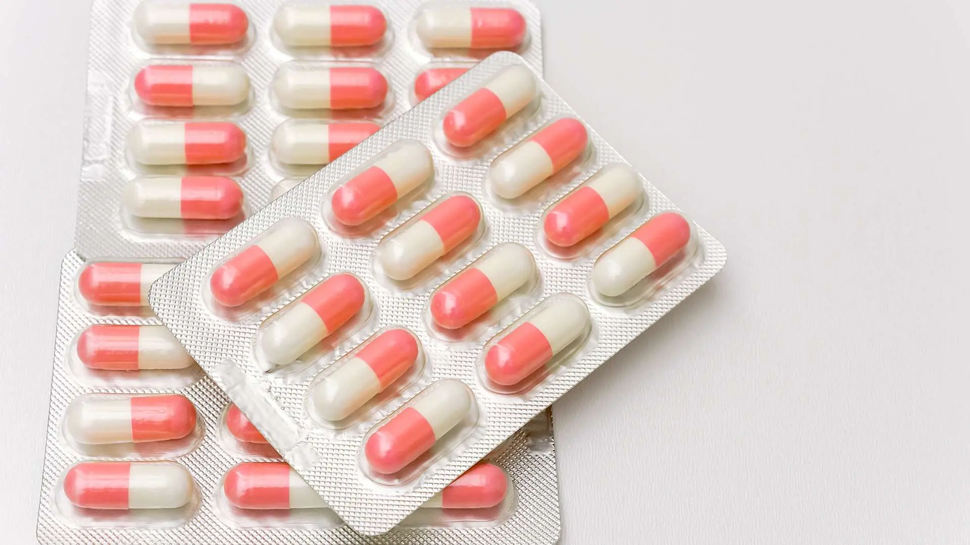 Gros plan trois plaquettes d'antibiotiques blancs et rouges